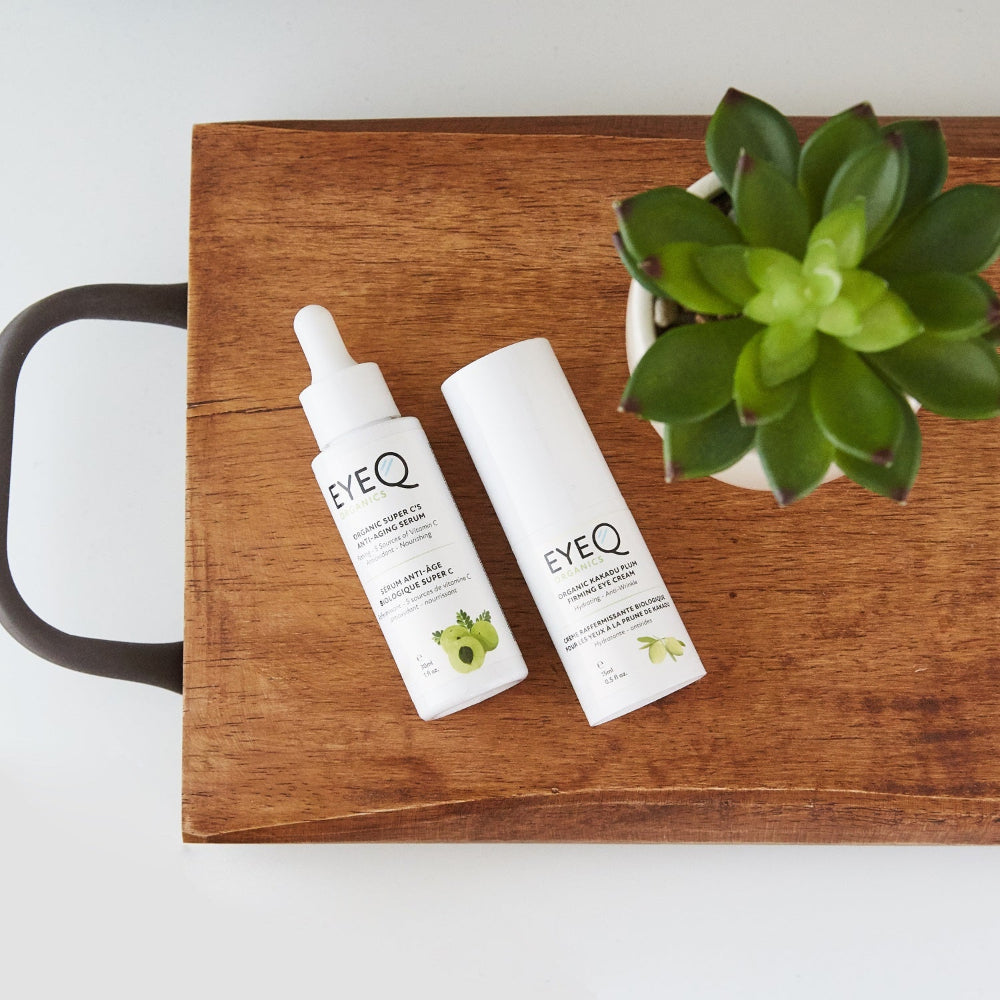 Two EYE Q skincare products on a wooden tray with a plant. Pair  with EQO Super C’s Anti-Aging Serum for best results by using our recommended 2 easy step solution to hydrated & younger looking skin!